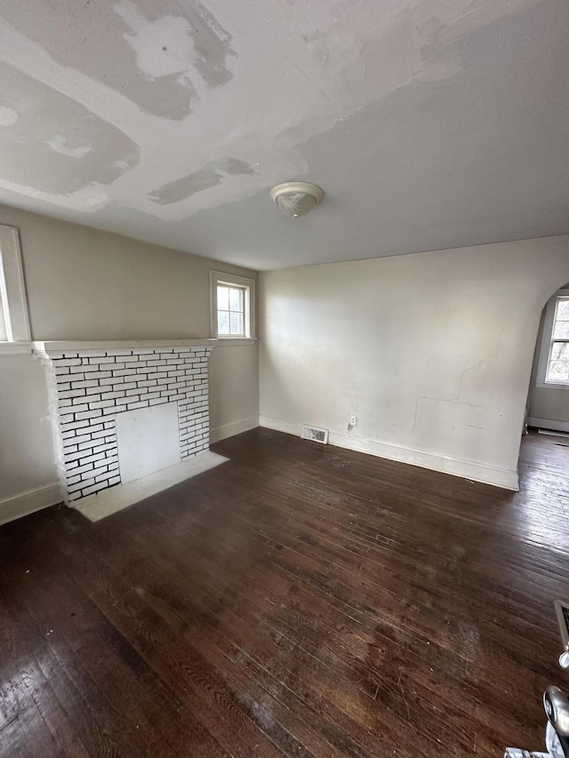 unfurnished living room with dark wood-type flooring