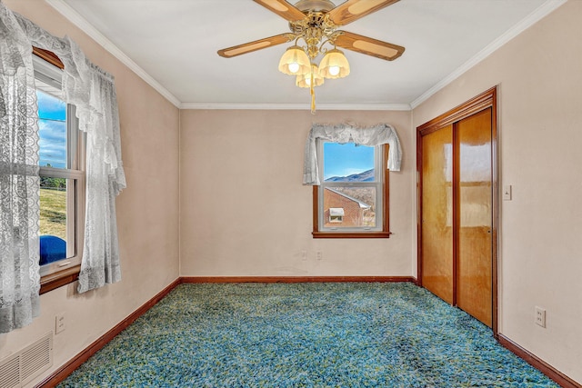 carpeted empty room featuring ceiling fan and crown molding