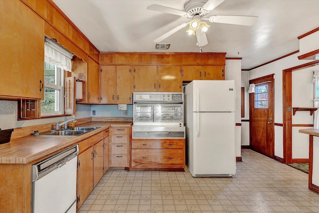 kitchen with white appliances, ceiling fan, ornamental molding, and sink