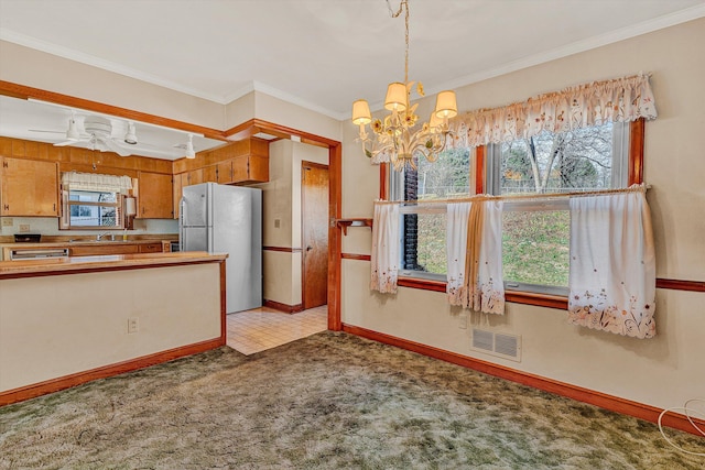 kitchen featuring sink, an inviting chandelier, light colored carpet, fridge, and ornamental molding