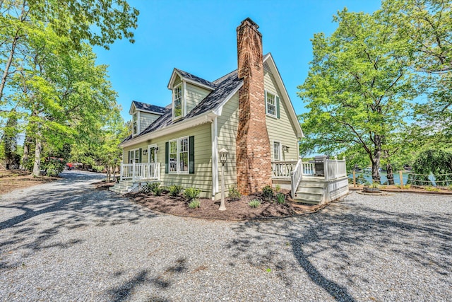 view of side of home with a deck and a chimney