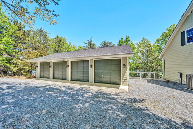 detached garage featuring fence and central AC