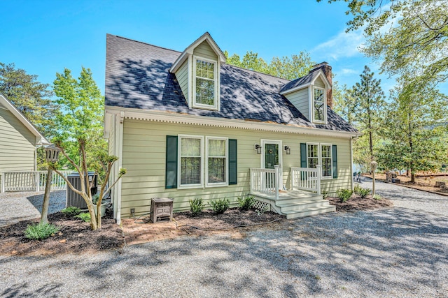 cape cod house with fence and a chimney