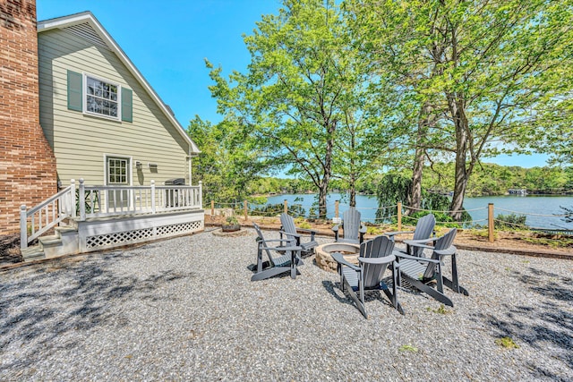 view of yard featuring a deck with water view and a fire pit