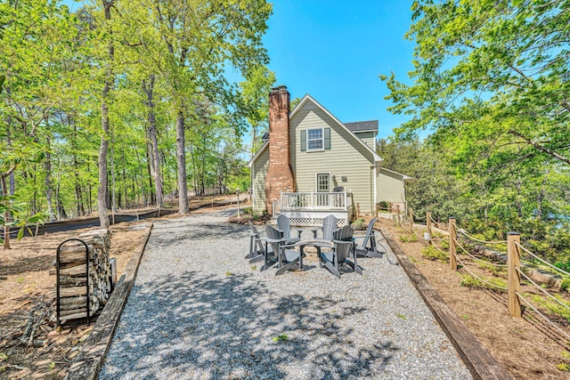 rear view of house with a chimney and an outdoor fire pit