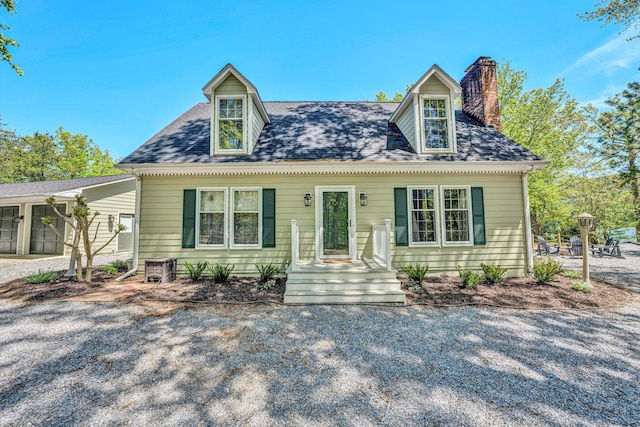 cape cod house with a chimney and a shingled roof
