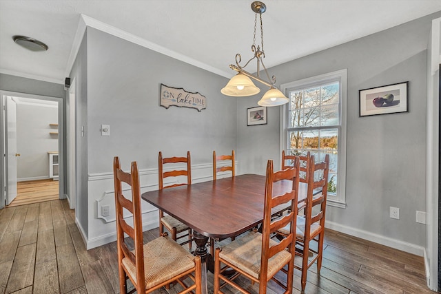 dining area featuring ornamental molding, hardwood / wood-style flooring, and baseboards