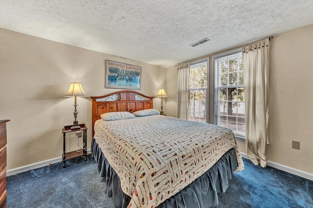 bedroom with a textured ceiling, visible vents, dark colored carpet, and baseboards