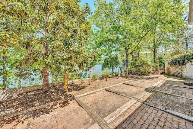 view of yard featuring fence, a water view, and a patio area