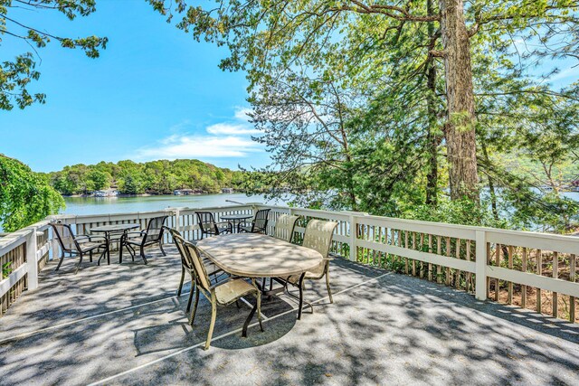 wooden deck featuring outdoor dining area and a water view