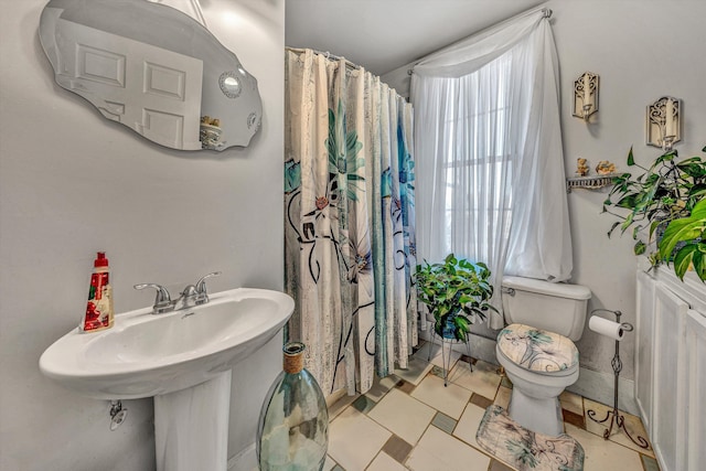 bathroom with sink, a shower with curtain, and toilet