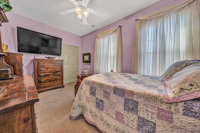 bedroom with ceiling fan, multiple windows, and carpet floors