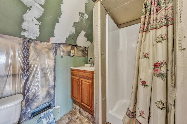 bathroom featuring tile patterned flooring, curtained shower, vanity, and toilet