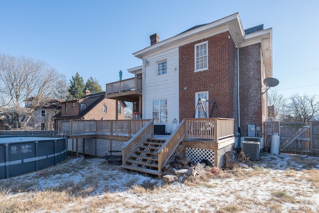 rear view of property with central AC unit and a pool side deck