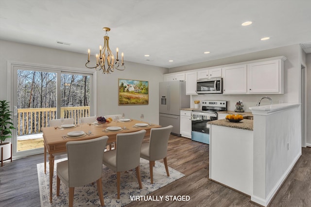 dining space featuring dark wood-type flooring, recessed lighting, visible vents, and a notable chandelier