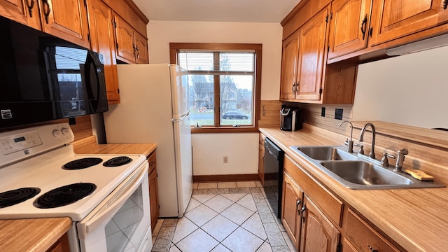 kitchen featuring black appliances, decorative backsplash, light tile patterned floors, and sink