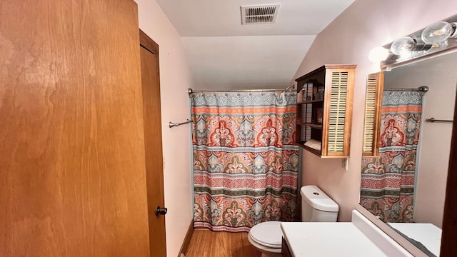 bathroom featuring a shower with shower curtain, vanity, hardwood / wood-style flooring, toilet, and lofted ceiling