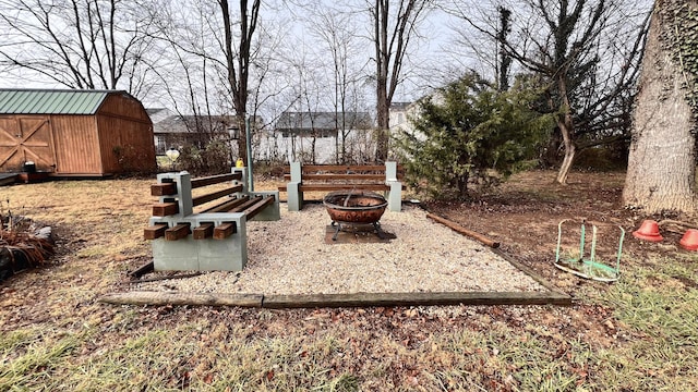 view of yard featuring a fire pit and a shed