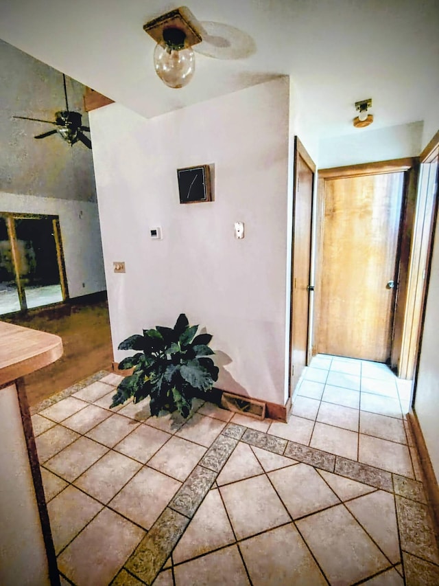 hall with tile patterned floors