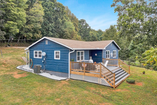 view of front facade featuring central air condition unit, a front yard, and a deck