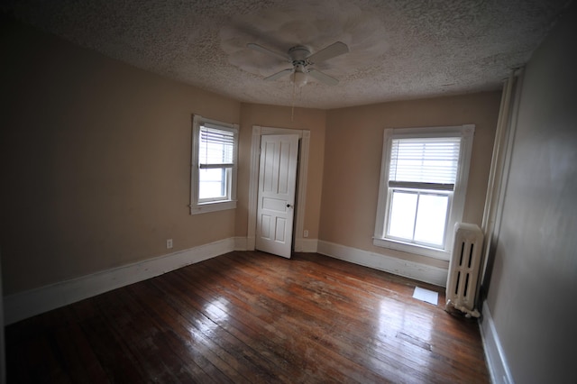 unfurnished bedroom with radiator, ceiling fan, dark hardwood / wood-style flooring, and a textured ceiling