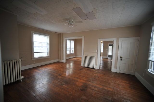 unfurnished room featuring radiator heating unit, dark hardwood / wood-style floors, ceiling fan, and ornamental molding