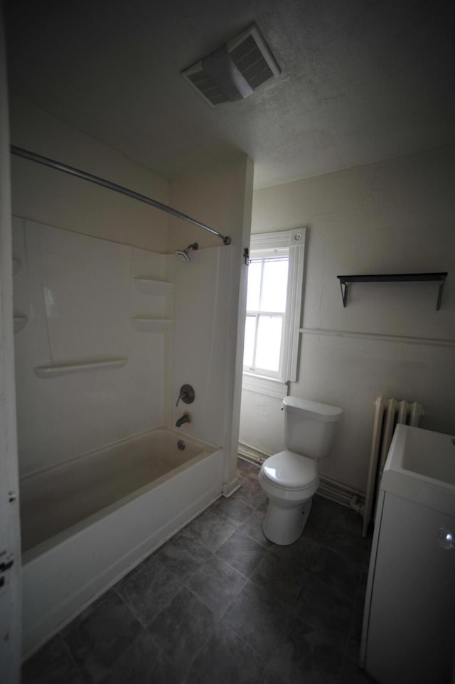 bathroom with radiator, shower / bathing tub combination, and toilet