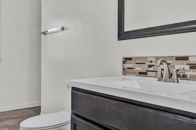 bathroom with vanity, toilet, and backsplash