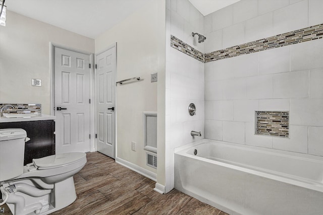 full bathroom with sink, tiled shower / bath combo, and toilet