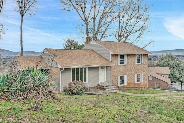 tri-level home featuring a mountain view and a front lawn