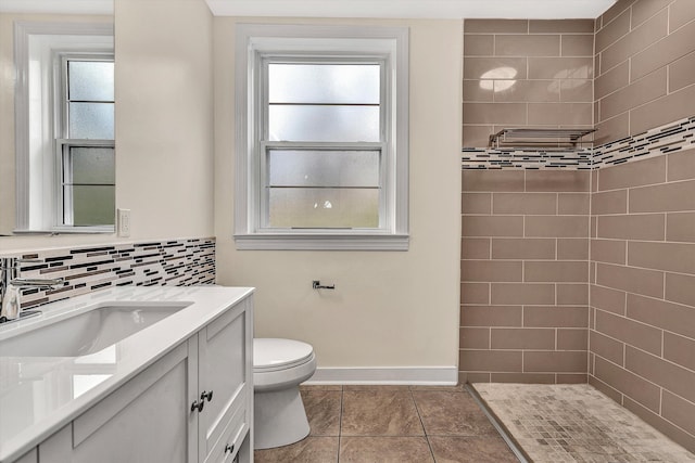 bathroom featuring tile patterned flooring, vanity, toilet, and a wealth of natural light