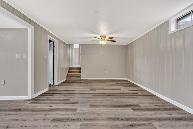 spare room featuring wood-type flooring, ceiling fan, and crown molding