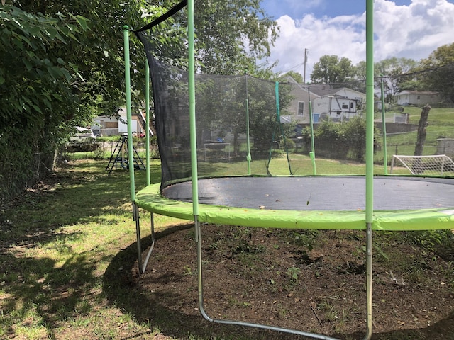 view of property's community featuring a lawn and a trampoline