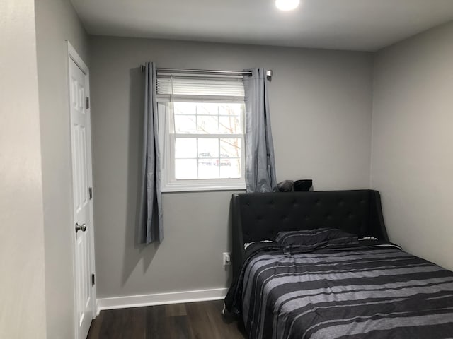 bedroom with dark hardwood / wood-style flooring