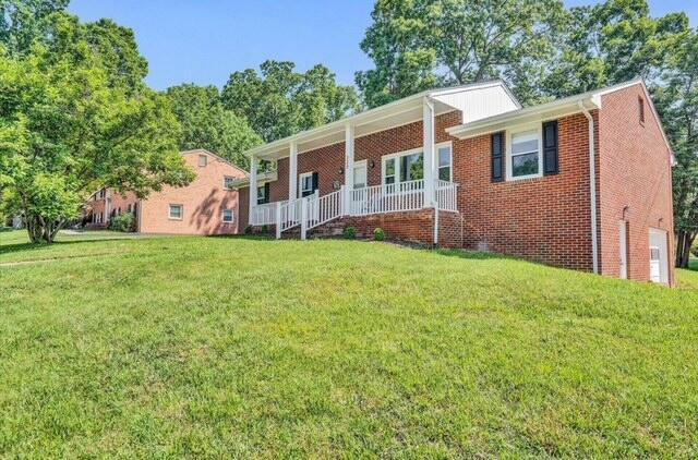 single story home with a porch and a front yard