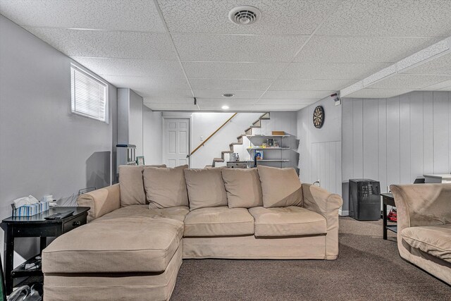 carpeted living room featuring a paneled ceiling