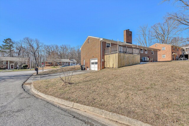 rear view of property with a wooden deck and a lawn