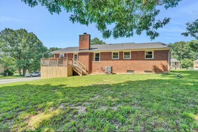 exterior space featuring central AC unit, a garage, and a lawn