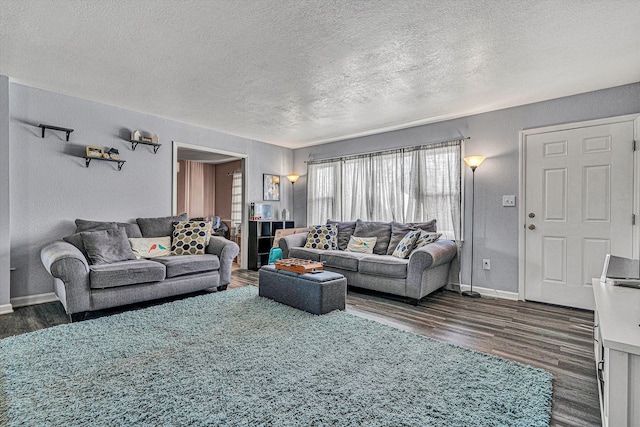 living room featuring a textured ceiling and dark wood-type flooring