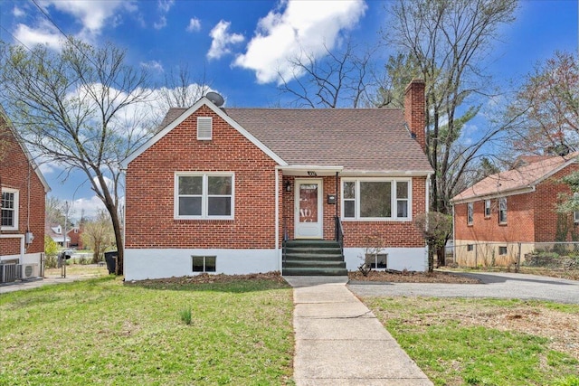 bungalow-style home featuring fence, a front yard, a shingled roof, brick siding, and a chimney