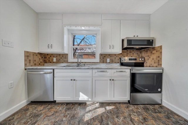 kitchen with white cabinets, sink, light stone countertops, appliances with stainless steel finishes, and tasteful backsplash