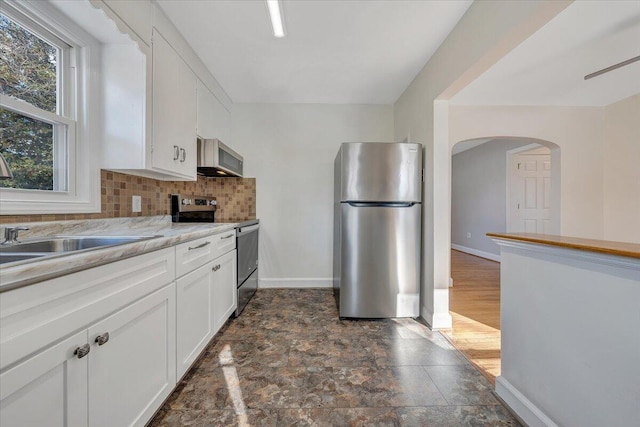 kitchen with sink, white cabinetry, backsplash, and appliances with stainless steel finishes