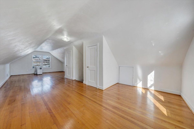 additional living space with lofted ceiling and light wood-type flooring