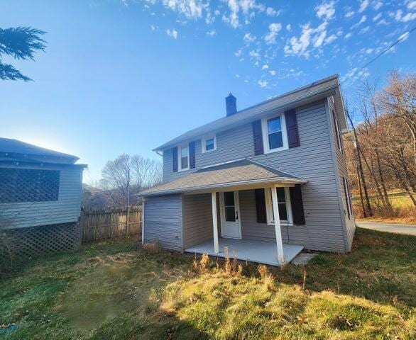 rear view of house with a lawn and a patio area