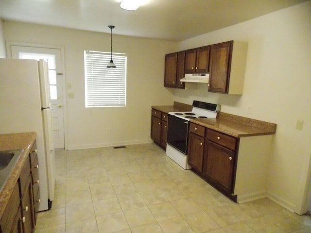 kitchen with dark brown cabinets, a healthy amount of sunlight, white appliances, and hanging light fixtures