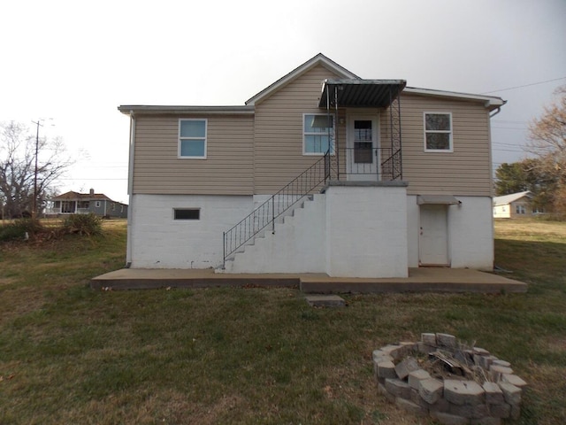 rear view of property with a lawn and an outdoor fire pit