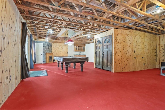 basement featuring pool table and wooden walls