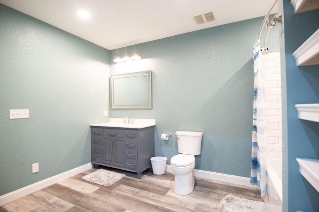 full bathroom featuring vanity, wood-type flooring, shower / tub combo, and toilet