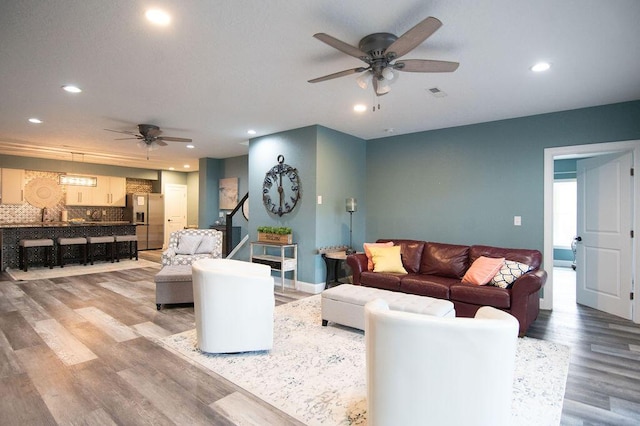 living room featuring hardwood / wood-style flooring and ceiling fan