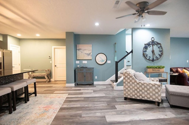 living room featuring ceiling fan and light hardwood / wood-style floors